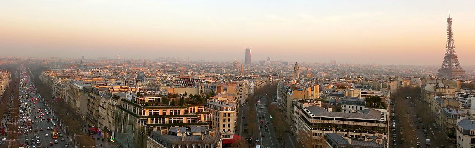 View of the Paris skyine at night. the Eiffel tower is in the background with the other city buildings in the foreground.